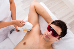 High Angle View Of A Therapist Giving Laser Epilation Treatment On Mans Armpit